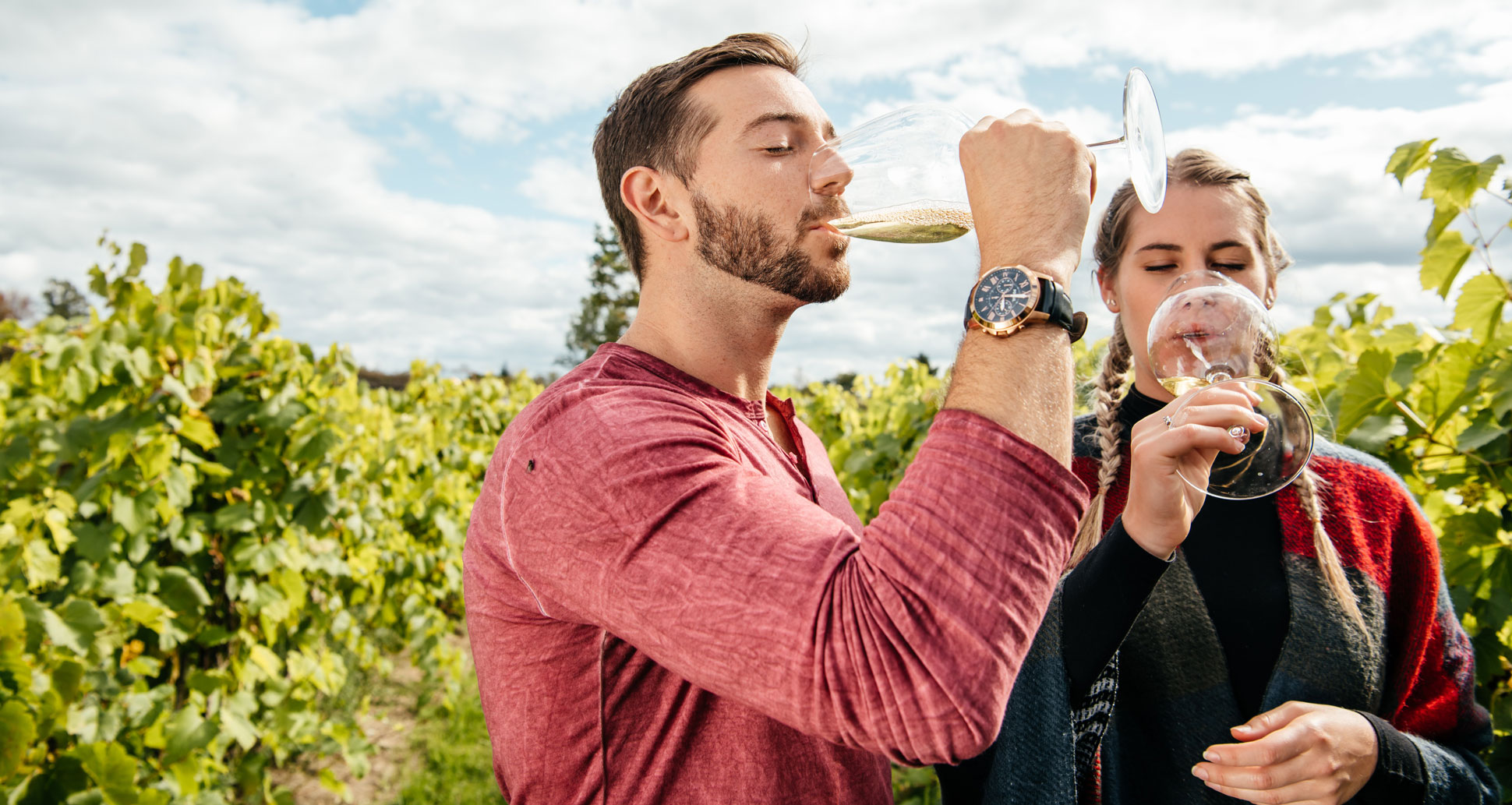 Man and a woman enjoying a glass of wine within a vineyard