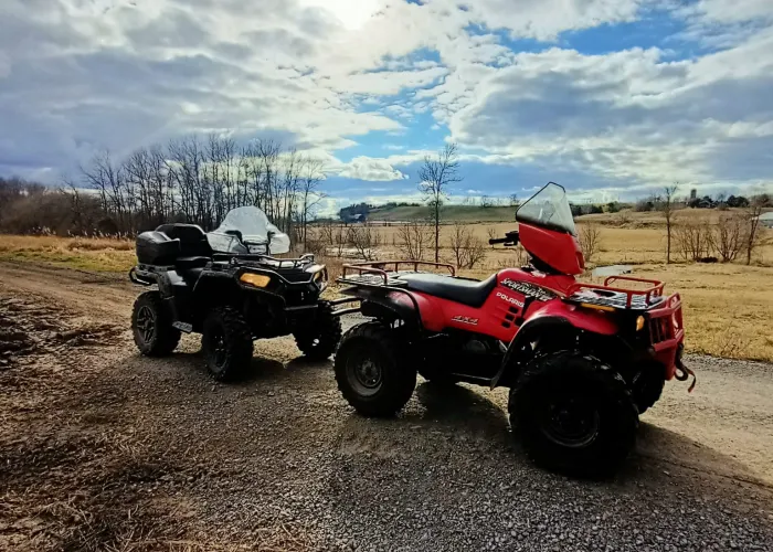 Two ATVs stopped on a trail