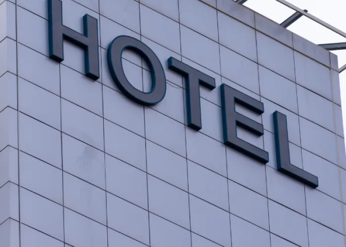 Picture of a hotel. A grey building with the words HOTEL large on the side.